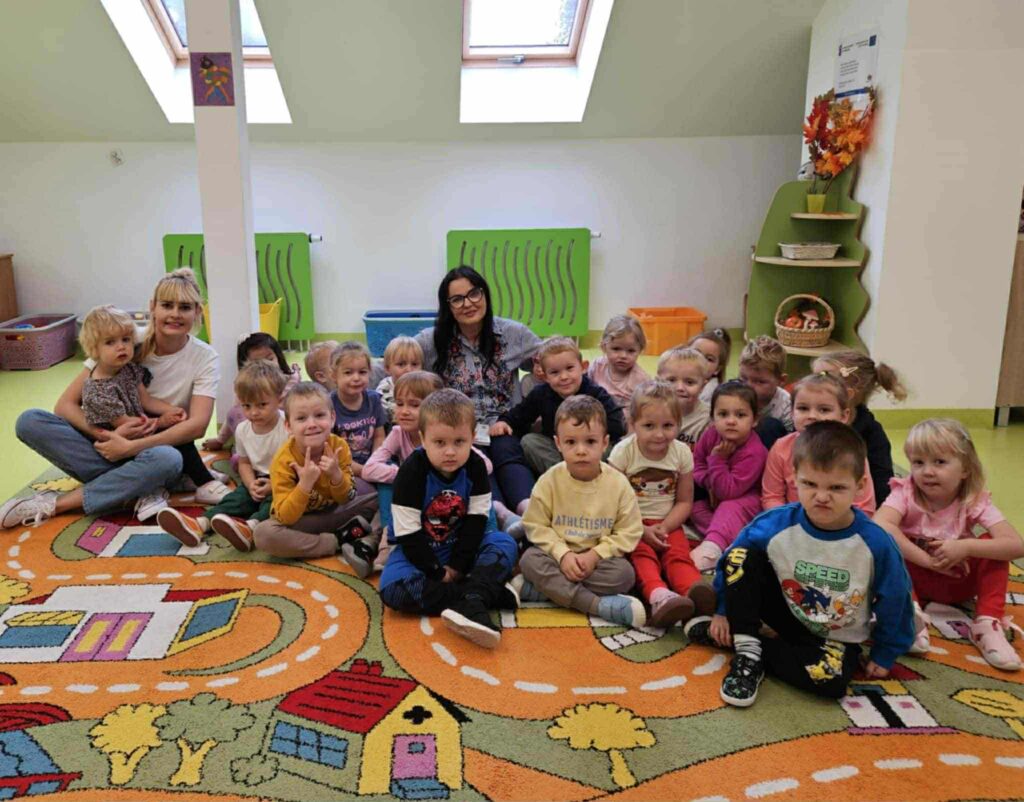 2 kobiety i dzieci siedzą na dywanie